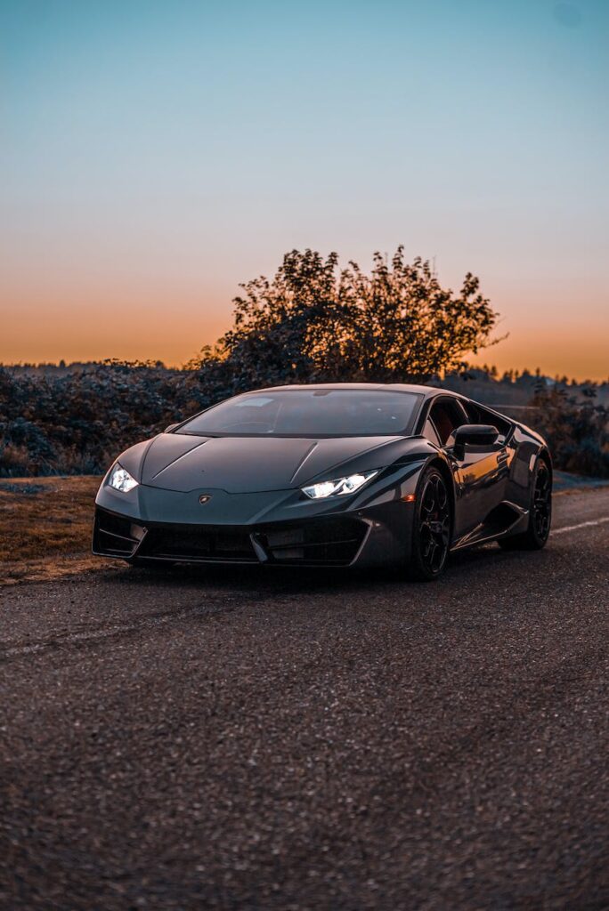 lamborghini huracan parked on asphalt road at sunset